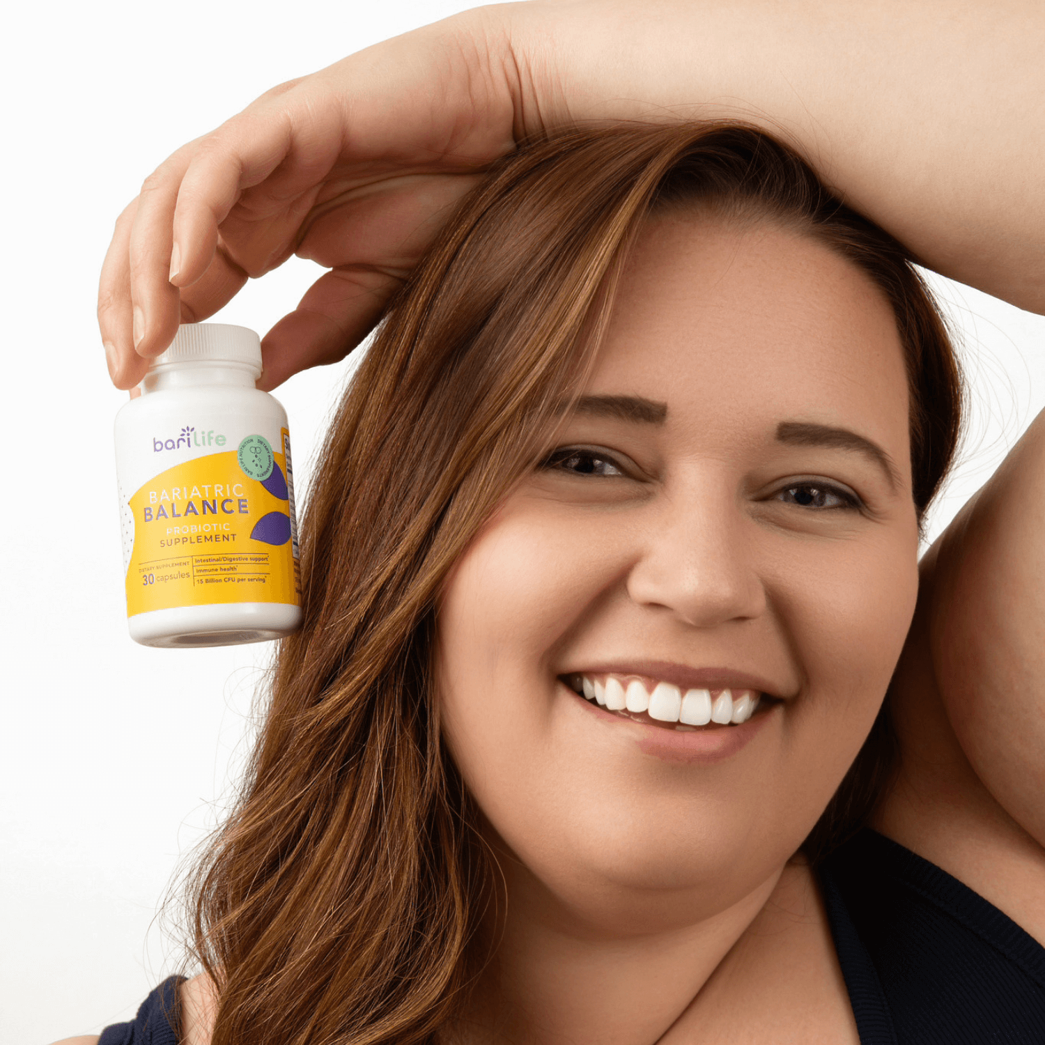Smiling woman holding Bariatric Balance probiotic supplement bottle, promoting gut health for weight loss.